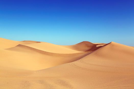 Mountainous dunes under an azure blue sky