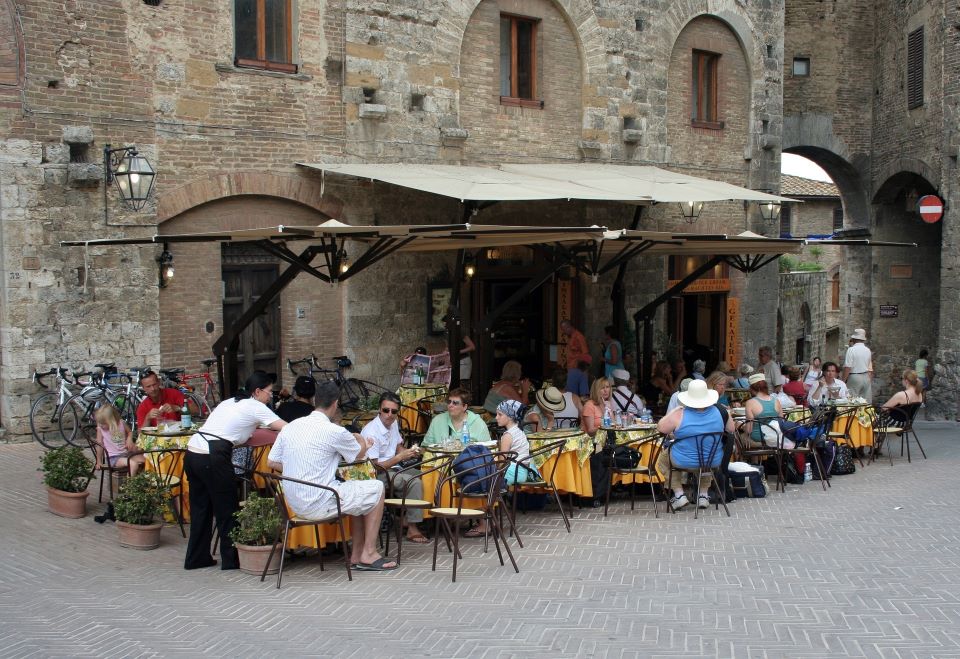 A crowd of people dining outside at the front of a restaurant