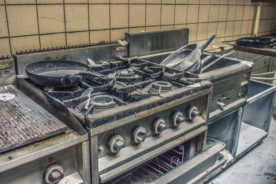 Rusty frying pans on top of kitchen ovens that have not been used for years