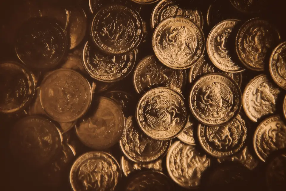 A pile of shiny Mexican coins